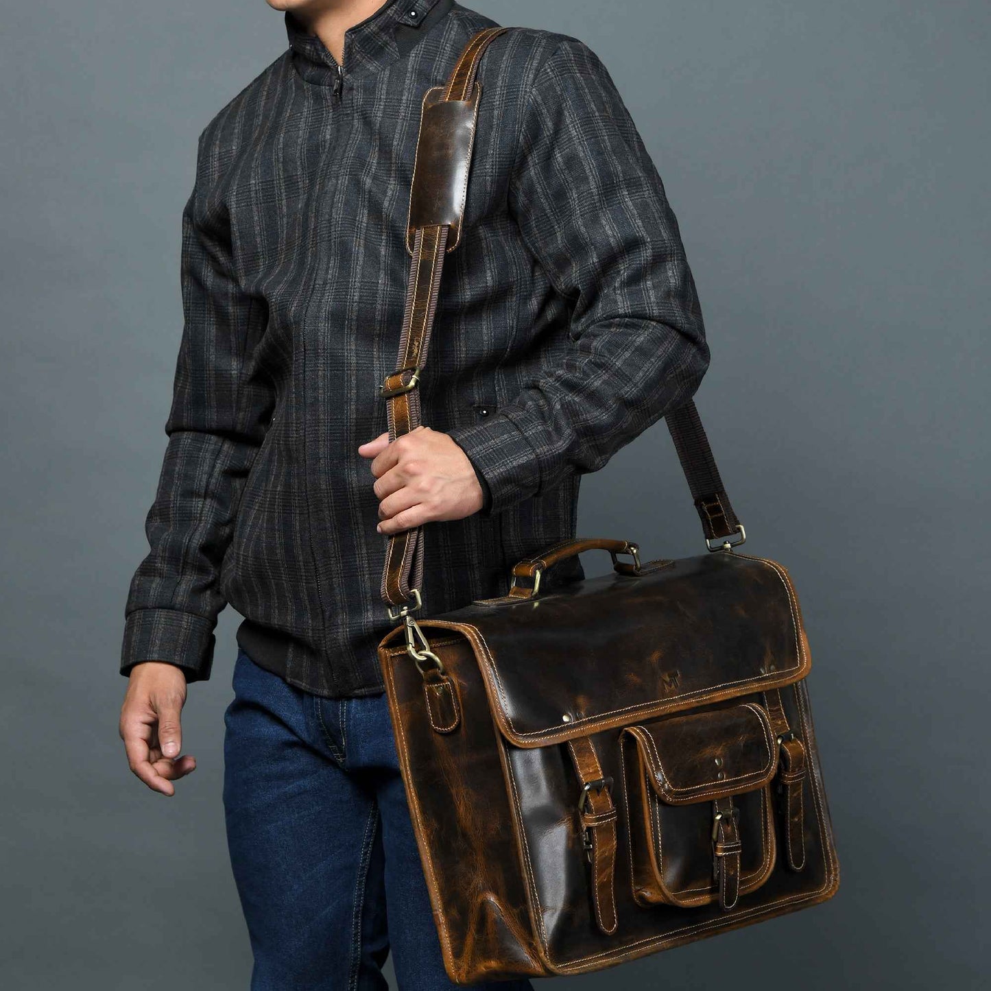 Vintage leather laptop satchel in dark brown with front flap and multiple pockets.