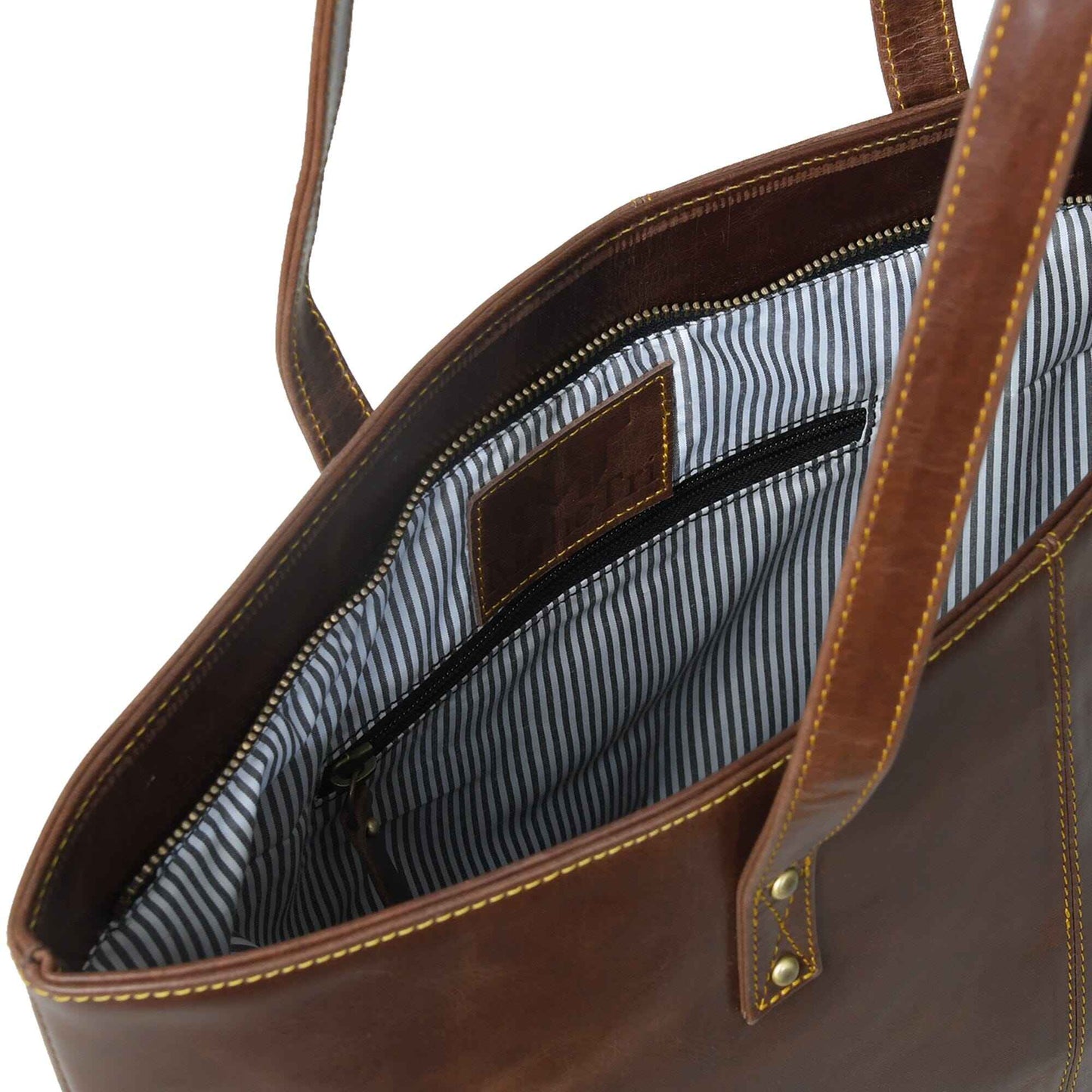 Leather tote bag interior with striped lining and zipped pocket, showing top opening
