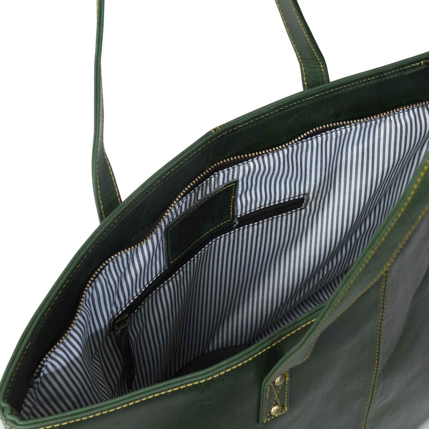Green leather tote interior with striped pocket and zippered opening edge.