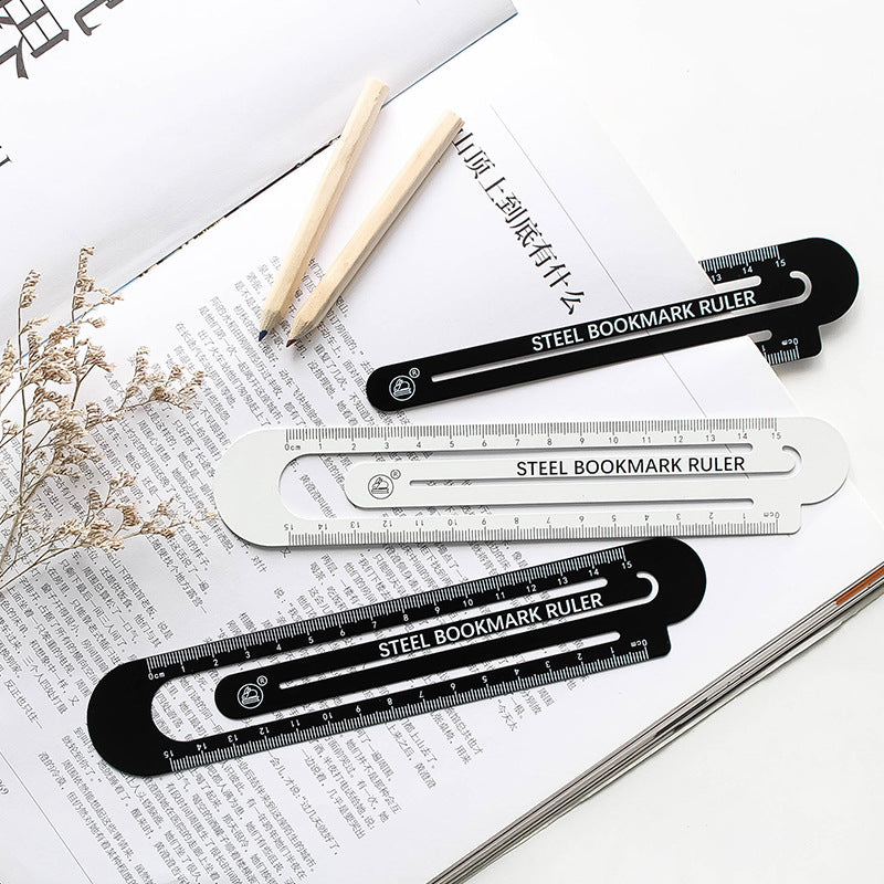 Steel bookmark ruler, black and white hollow 12 cm rulers laid on papers.