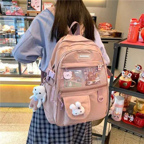 Teen backpack in light pink with mesh front pocket and plush bear charm