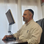 A dedicated scholar in Israel using modern ergonomic tools for traditional learning and focus.